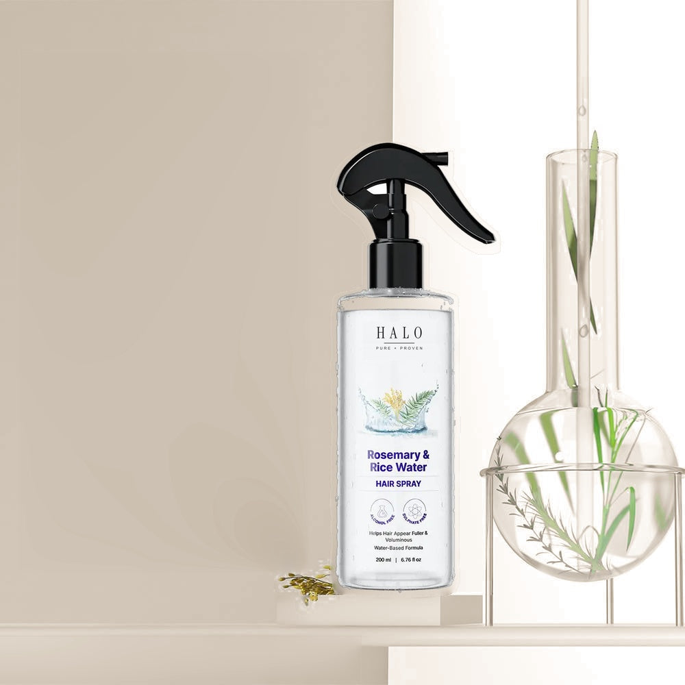 The Bare Anatomy bottle on a shelf beside a glass flask of rosemary steeping in water